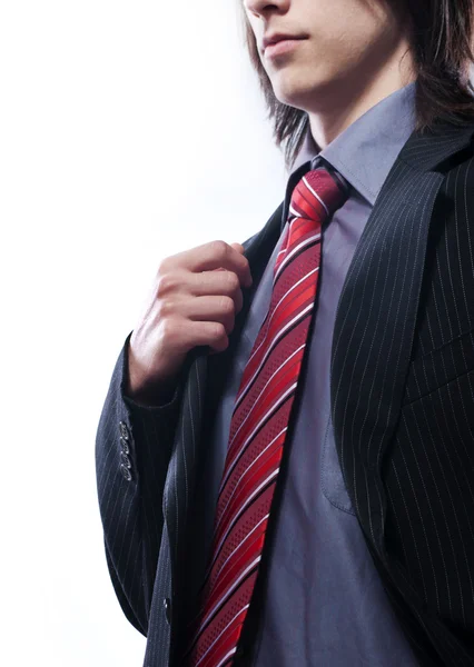 Young businessman with long hair, straightens his jacket. — Stock Photo, Image