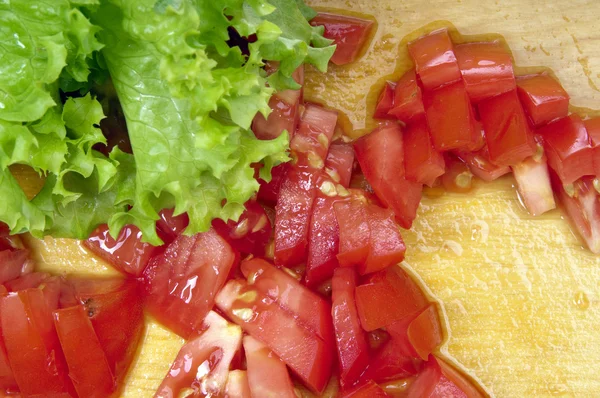 Tomates fatiados e alface fresca no tabuleiro — Fotografia de Stock