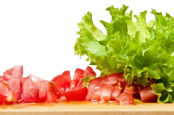 stock image Sliced tomatoes and the fresh lettuce on the board