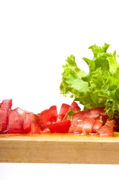 Sliced tomatoes and the fresh lettuce on the board — Stock Photo, Image