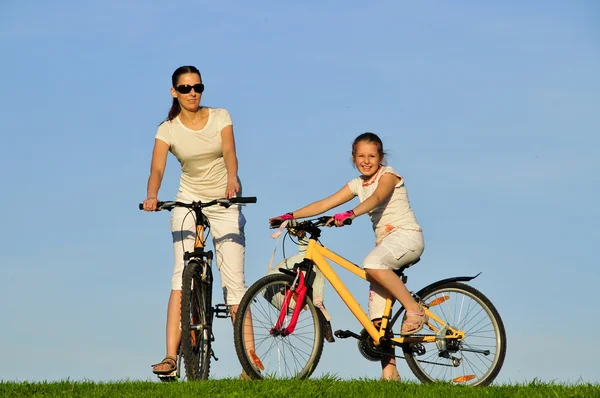 Mother and her dauhgter riding on a bicycles — Stock Photo, Image
