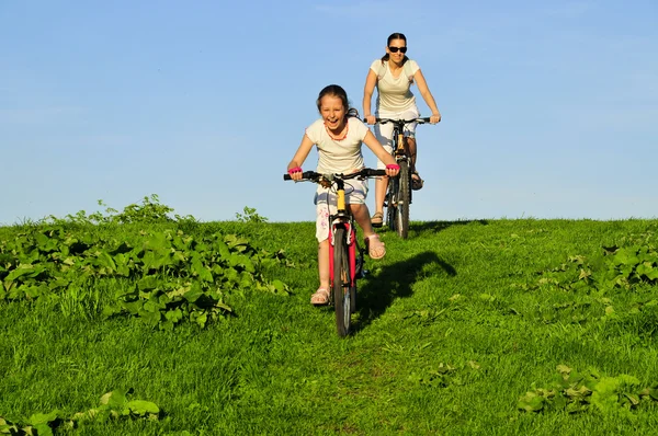 母亲和她骑在自行车上的 dauhgter — 图库照片