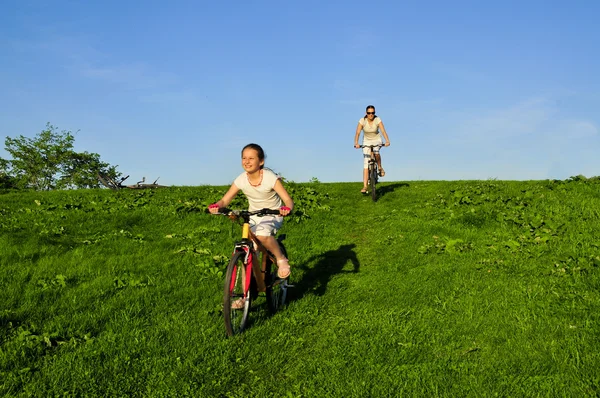 母亲和她骑在自行车上的 dauhgter — 图库照片