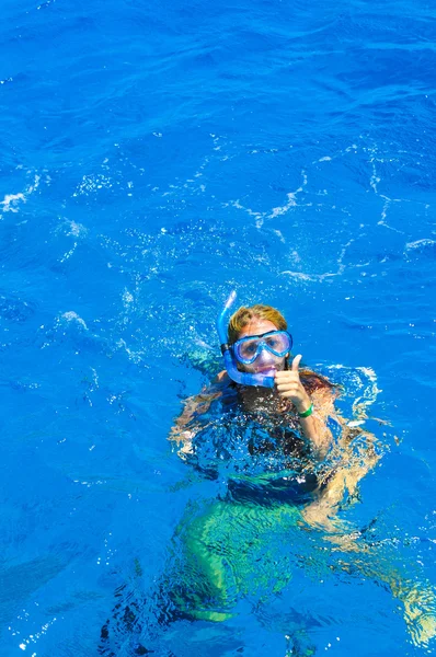 La hermosa chica está haciendo snorkel con una máscara en un mar rojo — Foto de Stock