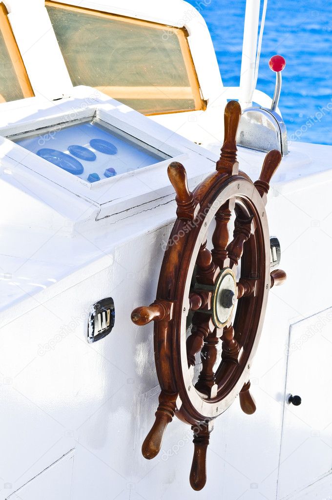 The wood steering wheel of a captain's bridge on the yacht