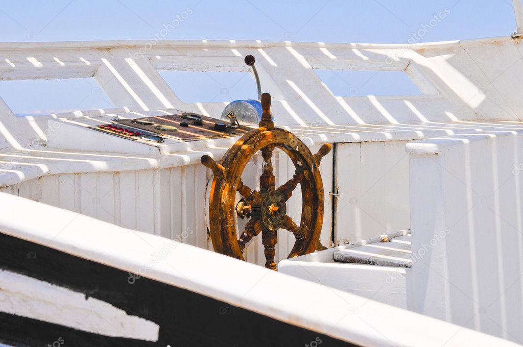 The wood steering wheel of a captain's bridge on the yacht
