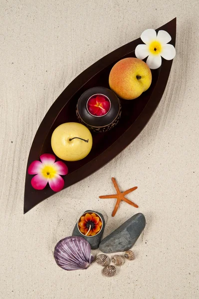Фрукти з маленькою квітковою свічкою в дерев'яному лотку — стокове фото