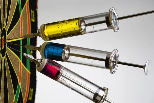 Injekční stříkačky s barevnými tekutinami hity cíl — Stock fotografie
