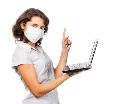 Strict girl in a protective mask with a laptop