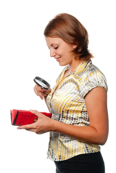 Menina sorridente considera uma bolsa através de uma lupa — Fotografia de Stock
