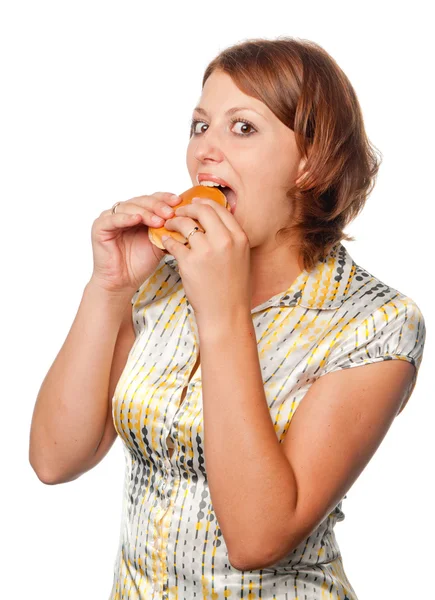 Menina sorridente considera um hambúrguer através de uma lupa — Fotografia de Stock