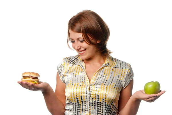 Flickan väljs mellan apple och hamburgare Stockfoto