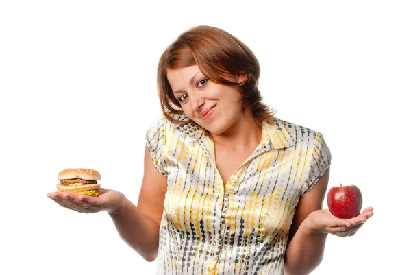 Girl is chosen between apple and hamburger Stock Image