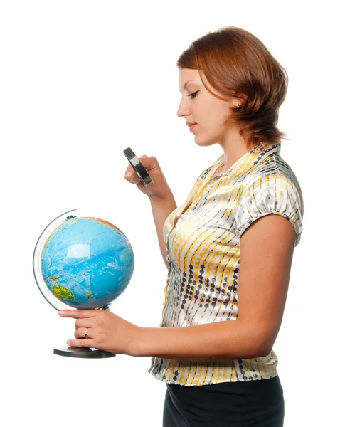 Девушка рассматривает земной шар через увеличитель — стоковое фото