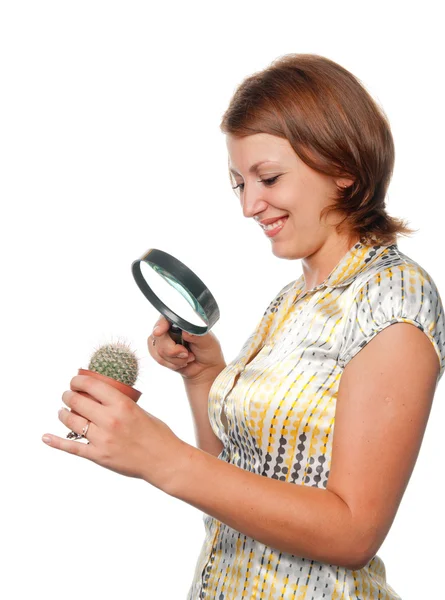 Girl considers a cactus through a magnifier — Stock Photo, Image
