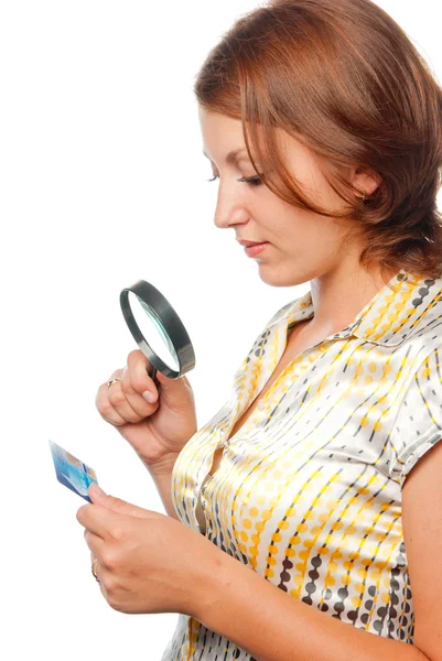 Meisje acht een creditcard via een vergrootglas — Stockfoto