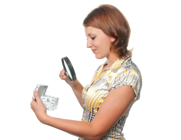 Girl looks at a gift through a magnifier — Stock Photo, Image