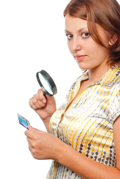 Meisje acht een creditcard via een vergrootglas — Stockfoto