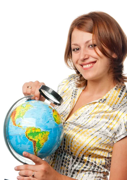 Smiling girl examines the globe through a magnifier — Stock Photo, Image