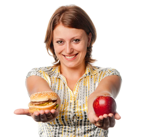 Усміхнена дівчина розтягує яблуко і гамбургер — стокове фото