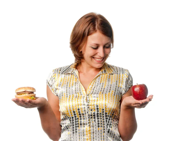 Дівчину вибирають між яблуком і гамбургером — стокове фото