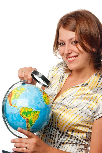 Smiling girl examines the globe through a magnifier — Stock Photo, Image