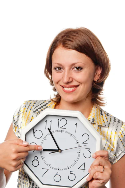 Smiling girl points a finger at clock Stock Image