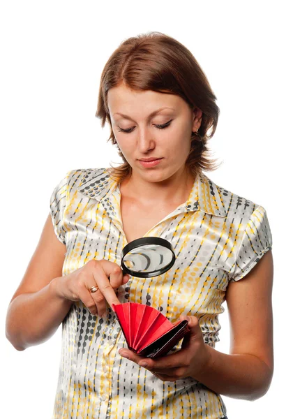 Girl considers a purse through a magnifier Stock Image