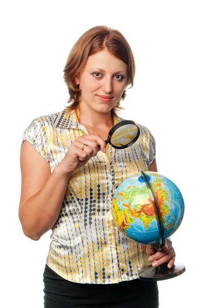 Girl examines the globe through a magnifier Stock Picture