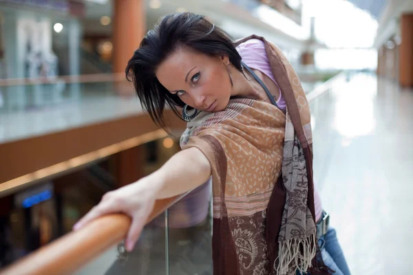 Kız alışveriş arka plan üzerinde poz bir eşarp ile — Stok fotoğraf