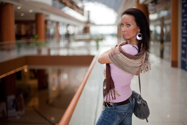 一条围巾在购物中心背景的女孩 免版税图库图片