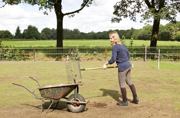 Girl cleaning the manure — Stock Photo, Image