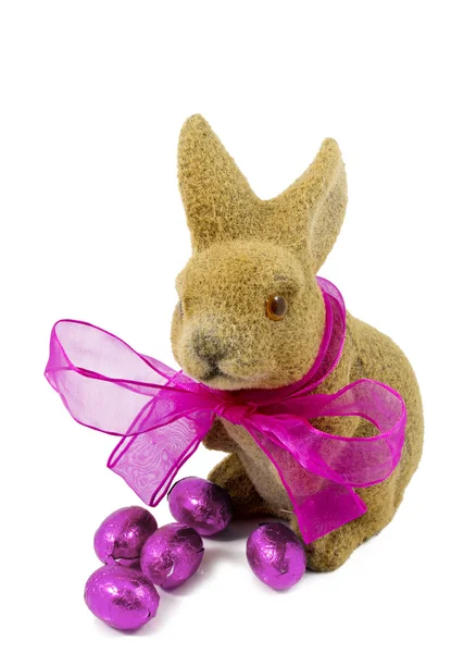 Easter bunnie with pink bow and Easter eggs. — Stock Photo, Image