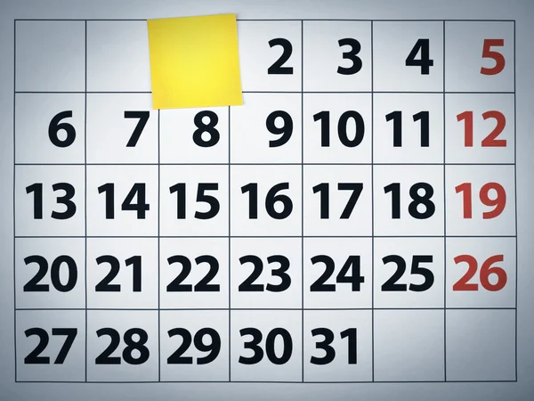 Blanco plakkerige noot op een kalender — Stockfoto
