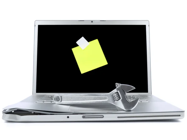 Laptop com nota pegajosa e ferramenta — Fotografia de Stock