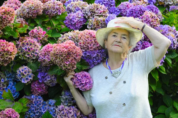Mulher velha com flores — Fotografia de Stock