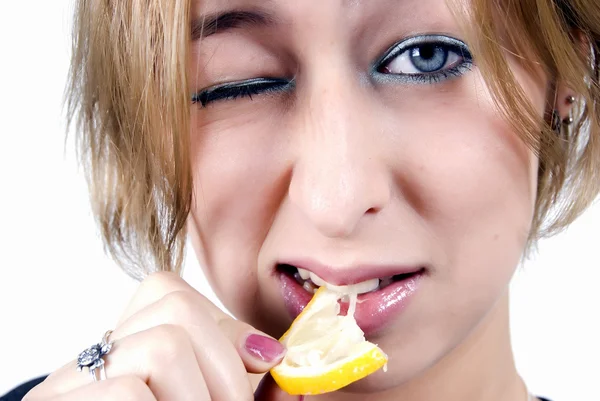 Девушка ест лимон — стоковое фото
