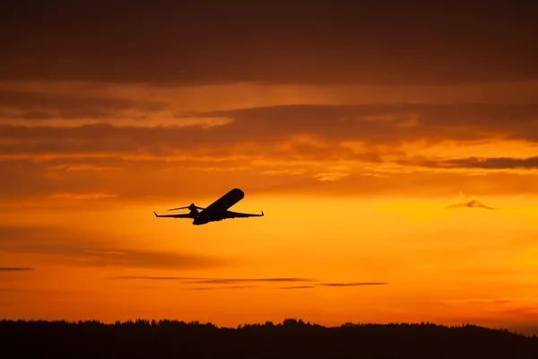 Vliegtuig opstijgen in zonsondergang — Stockfoto