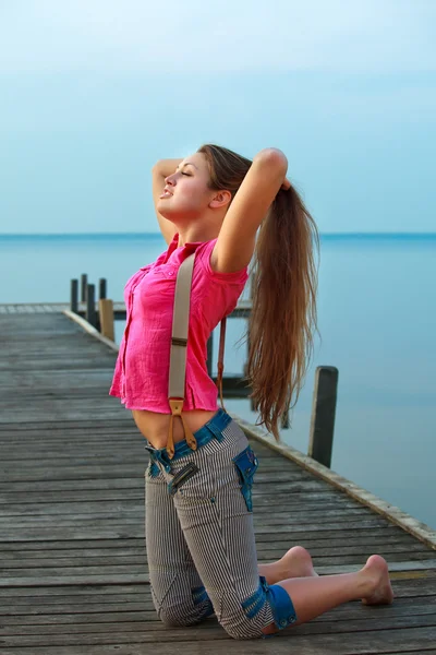 Rilassante giovane donna sul ponte in estate — Foto Stock