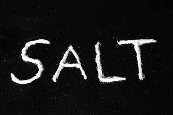 Соль на черной поверхности — стоковое фото