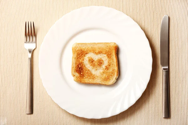Тост и сердце на тарелке — стоковое фото