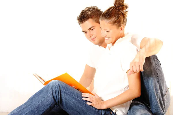 Jovem casal lendo um livro — Fotografia de Stock