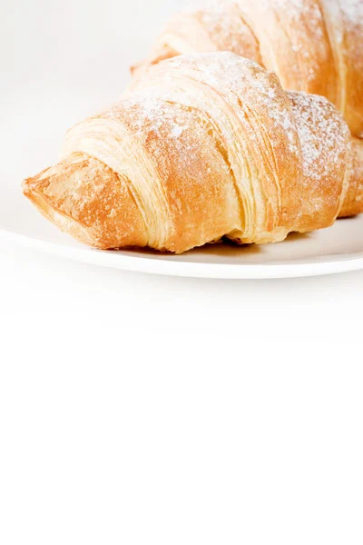 Fresh croissants on white plate with empty space below — Stock Photo, Image