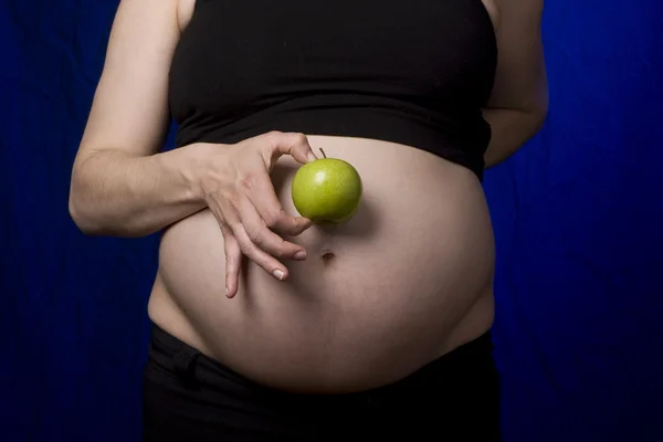 Pregnant belly and apple — Stock Photo, Image