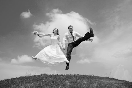 Mariée et fiancée sautant sur fond de ciel. Dans toute croissance .