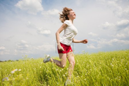 Heureuses jeunes femmes qui courent dans le champ 