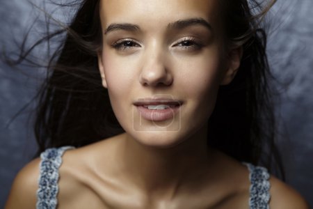 Portrait de belle femme glamour posant en fond bleu 