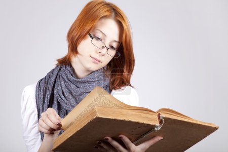 Jeune fille de mode douteuse dans des lunettes avec vieux livre 
